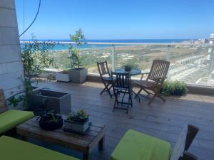 a patio with chairs and a table on a balcony at Tirat Carmel Penthouse in Tirat Karmel