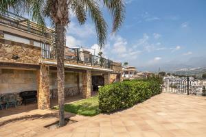 una casa con una palmera y un patio en Vista Lara. Relájate y disfruta. en Nerja