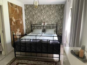 1 dormitorio con cama negra y pared en Kostastugan, en Kosta