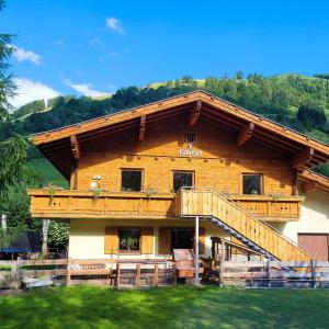 a large wooden house with a staircase on it at Ritterhof Apartments in Rauris