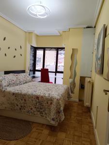 um quarto com uma cama e uma cadeira vermelha em Los Bolardos em Zamora
