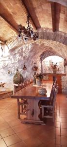 una sala da pranzo con tavolo e parete in pietra di La grotta di NiMa a Pretoro