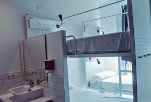 La salle de bains est pourvue de lits superposés et d'un lavabo. dans l'établissement Feel Hostels Soho Malaga, à Malaga