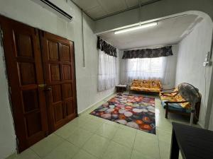 een kamer met een deur, een bank en een tapijt bij HOMESTAY NO.45 in Jitra