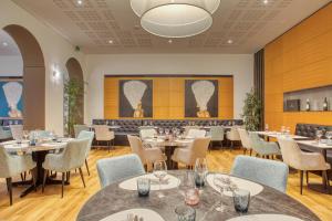 a restaurant with tables and chairs and a bar at Hôtel Au Terminus in Sierre