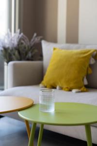 a green coffee table next to a couch with a yellow pillow at Bright & Chic Apartment with Mamad in the City by Sea N' Rent in Tel Aviv