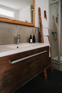 La salle de bains est pourvue d'un lavabo et d'un miroir. dans l'établissement Appartement Residenz Bella Italia - Charmante Unterkunft im Herzen von Würzburg mit Balkon, Terrasse und Parkplatz im Innenhof!, à Wurtzbourg