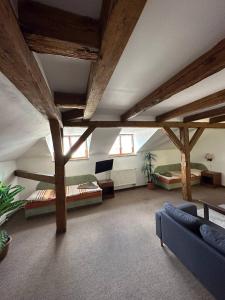 a large living room with wooden beams and a couch at Hotel U Radnice Aš in Aš