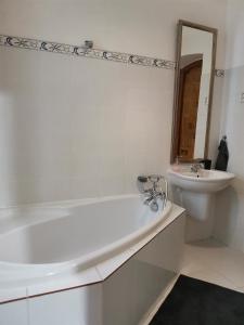 een witte badkamer met een bad en een wastafel bij Downtown 3 BDR Charm - walk to all attractions in Bratislava