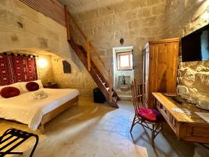 ein Schlafzimmer mit einem Bett und einer Treppe in einem Zimmer in der Unterkunft Ta' Ġilarda Boutique Living in Birbuba