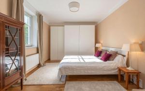 a bedroom with a large bed with purple pillows at Apartments am Kurpark in Bad Ischl