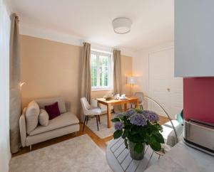 a living room with a table and a chair and a couch at Apartments am Kurpark in Bad Ischl