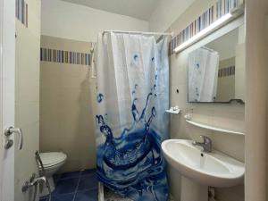 a bathroom with a blue and white shower curtain and a sink at Palmeraies vacances Tunis in La Marsa