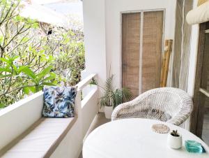 einen weißen Tisch und Stühle auf einem Balkon mit Pflanzen in der Unterkunft Seminyak Beach Tropical Hideaway Apartment in Seminyak