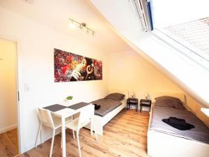 a bedroom with two beds and a table in a attic at Apartment in Trappenkamp near Kiel in Trappenkamp