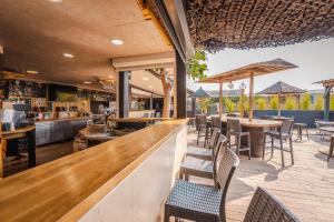 a restaurant with a bar with chairs and tables at Camping le Roucan West in Vias