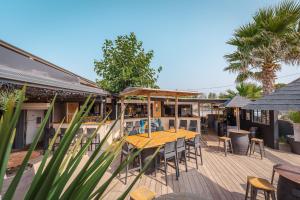 a wooden deck with a table and chairs on it at Camping le Roucan West in Vias