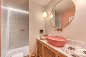 uma casa de banho com um lavatório rosa e um espelho. em The Shelf - Gîte & Love room em Bastogne