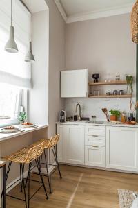 una cocina blanca con armarios y sillas blancos en Central Stylish Apartment en Budapest