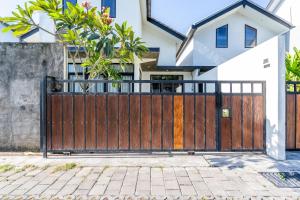 a wooden gate in front of a house at Ambara Residence Villa in Canggu