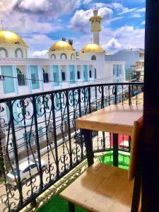 een balkon met een houten tafel en een gebouw bij Doze Hostel in Chiang Mai