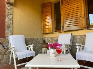 een tafel met een glas wijn en twee stoelen bij Villa Franca in Capoterra