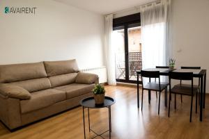 a living room with a couch and a table at El Serrablo AVAIRENT Sabiñánigo in Sabiñánigo