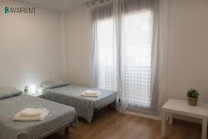 a room with two twin beds and a window at El Serrablo AVAIRENT Sabiñánigo in Sabiñánigo