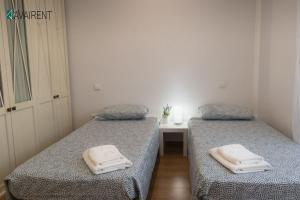two beds in a small room with towels on them at El Serrablo AVAIRENT Sabiñánigo in Sabiñánigo +7 photos