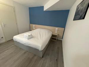 Cette petite chambre comprend un lit et un mur bleu. dans l'établissement 01.Studio#Creteil#Loft#Cinéma, à Créteil