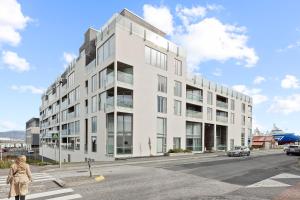 un edificio bianco all'angolo di una strada di Brand New Downtown Harbor Apartment a Reykjavik