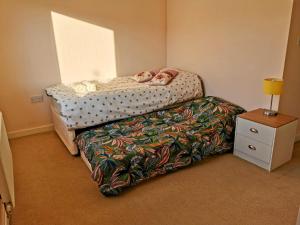 a small bedroom with a bed and a night stand at House with Breath of Fresh Air in Bloxwich