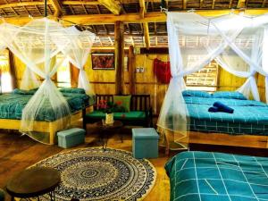 Hương Bá Thước的住宿－Pu Luong Homestay & Tours，一间卧室配有两张床、一张沙发和一张桌子