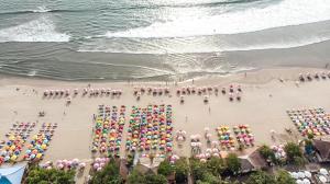 eine Luftaufnahme eines Strandes mit Sonnenschirmen in der Unterkunft Seminyak Beach Tropical Hideaway Apartment in Seminyak