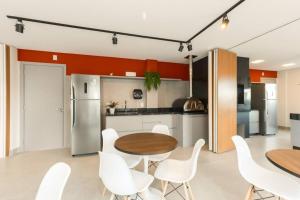 a kitchen with a wooden table and white chairs at Studio Batel in Curitiba