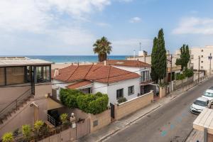 HHBCN Beach House Castelldefels #3 في كاستيلديفِيلس: شارع فيه بيوت والمحيط في الخلف