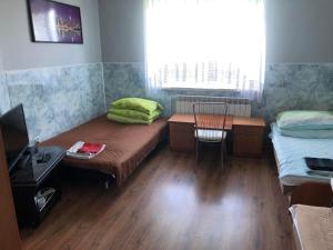 a room with a bed and a desk and a window at Zajazd Pod Świerkiem in Grajewo