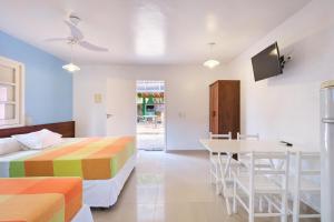 Un dormitorio con una cama y una mesa y sillas. en Pousada Sanremo Inn, en Ubatuba