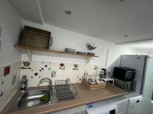 una piccola cucina con lavandino e frigorifero di Spacious basement studio apartment a Manchester