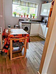 a small kitchen with a table and a stove at House with Breath of Fresh Air in Bloxwich