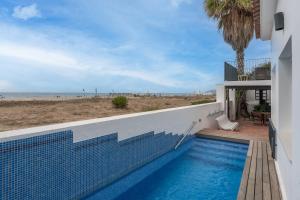 a swimming pool with a view of the beach at HHBCN Beach House Castelldefels #3 in Castelldefels