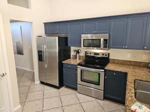 a kitchen with blue cabinets and stainless steel appliances at Villa Tortuga - Place to Relax in Cape Coral