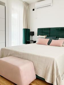 a bedroom with a large bed with pink pillows at VILA SLAVA in Vrnjačka Banja