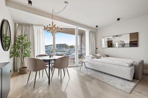 a living room with a bed and a table and chairs at Brand New Downtown Harbor Apartment in Reykjavík