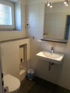 a bathroom with a sink and a toilet and a mirror at Ferienreihenhaus A, Ostseebad Dahme in Dahme