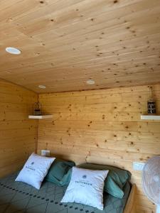 Habitación con 2 almohadas en una cabaña de madera en Chez Célia, Roulotte en Champagne en Fleury-la-Rivière