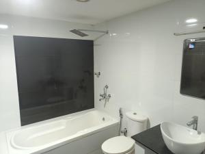 a bathroom with a tub and a toilet and a sink at Rain Homestay in Alleppey