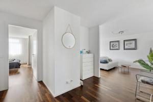a white living room with a bed and a mirror at Luxus 3-Zimmer Apartment mit Balkon & Homeoffice & Parkplatz in TOP-Lage nahe an Mercedes-Benz mit Kinderbetten in Böblingen