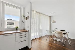 a kitchen with a table and a dining room at Luxus 3-Zimmer Apartment mit Balkon & Homeoffice & Parkplatz in TOP-Lage nahe an Mercedes-Benz mit Kinderbetten in Böblingen