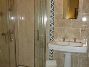 bagno con lavandino e specchio di The Red Lion Hotel a Spalding